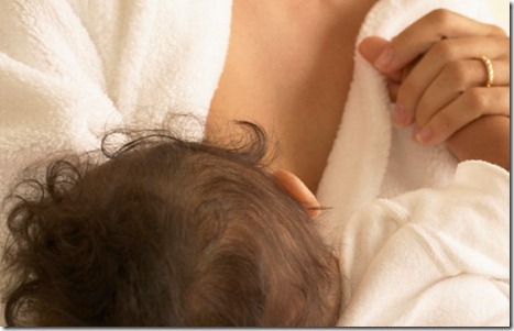 Young woman breast feeding a baby --- Image by © Royalty-Free/Corbis